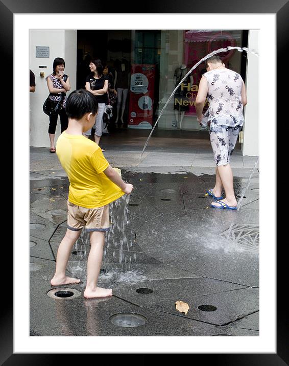 Boy in fountain  Framed Mounted Print by Hassan Najmy