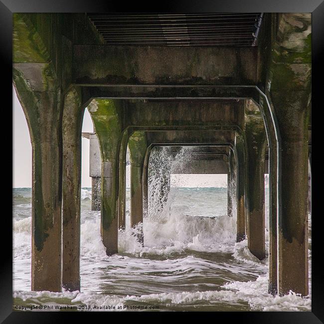 Waves under the pier Framed Print by Phil Wareham