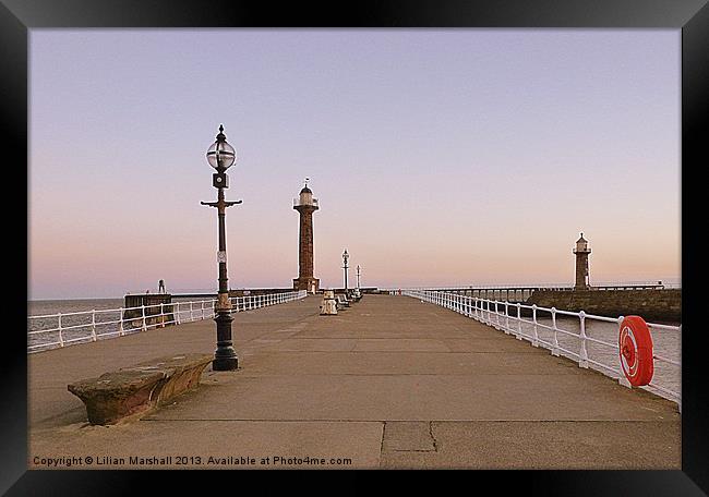 Sunrise over twin lighthouses. Whitby Framed Print by Lilian Marshall