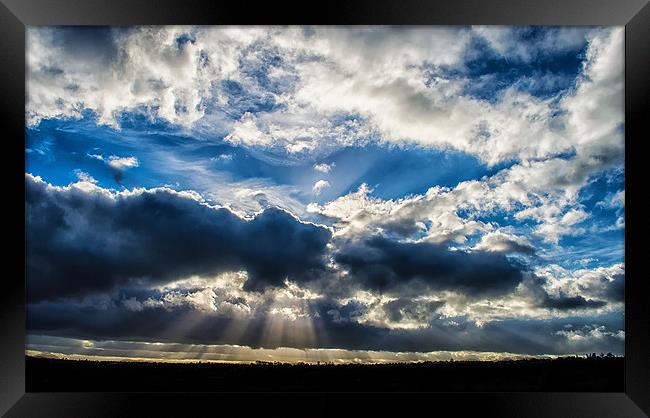 Breaking in the clouds, revealing the rays of beau Framed Print by