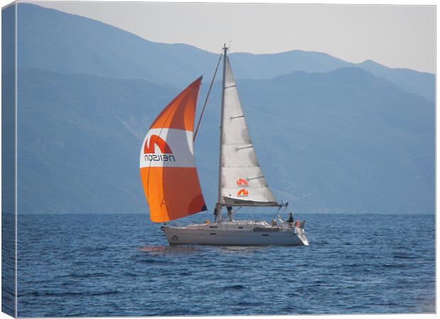 Youht with orange sail Canvas Print by Rodney Leith