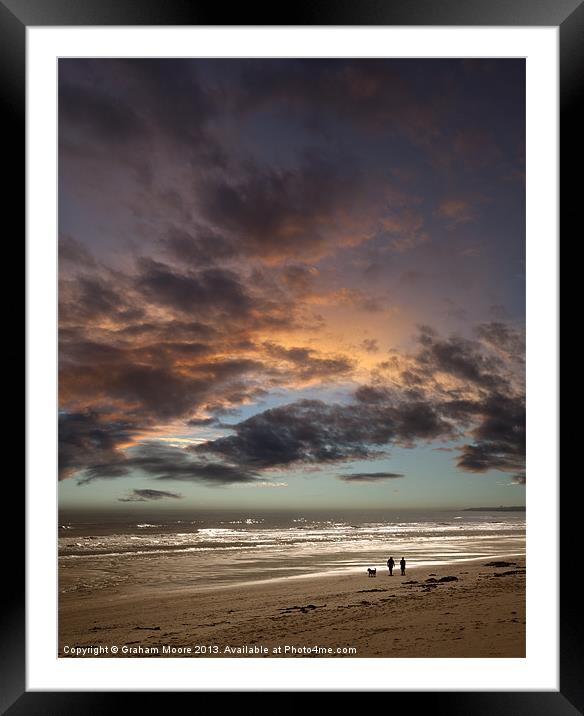 Couple walking on beach at sunset Framed Mounted Print by Graham Moore