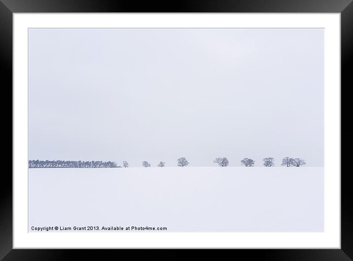 Snow covered field and trees on the horizon. East  Framed Mounted Print by Liam Grant