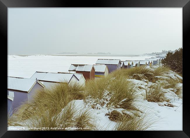 Sand dunes and beach huts covered in snow. Framed Print by Liam Grant