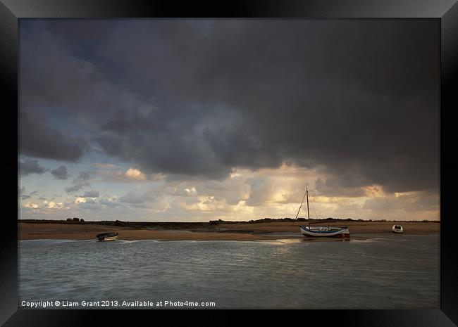 Storm over boats, Burnham Overy Staithe. Framed Print by Liam Grant