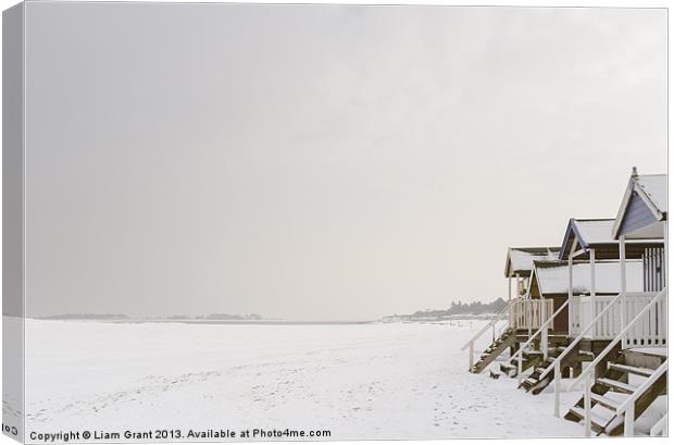 Beach huts covered in snow. Canvas Print by Liam Grant
