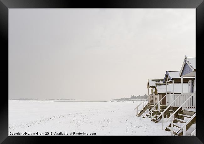 Beach huts covered in snow. Framed Print by Liam Grant