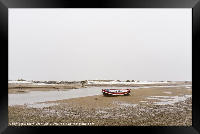Boat and snow. Burnham Overy Staithe. Framed Print by Liam Grant