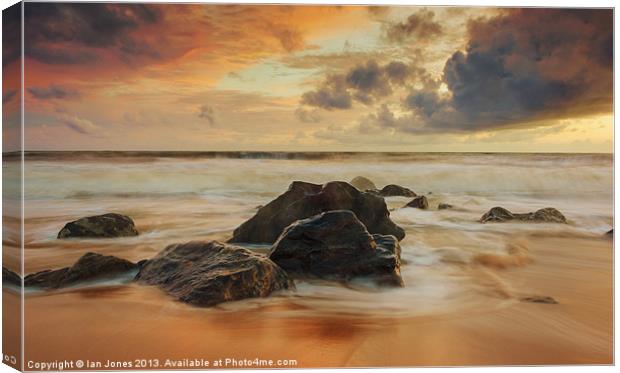 Sunset over the rocks Canvas Print by Ian Jones
