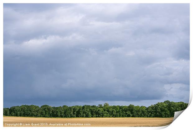Dramatic rainclouds over rural field Print by Liam Grant