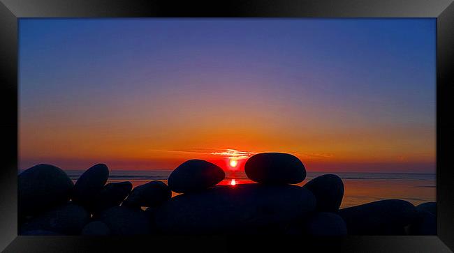 Sunset Through The Pebbles Framed Print by Pete Moyes