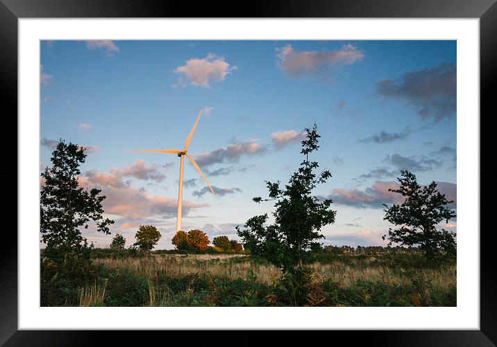 Wind turbine lit with evening light at sunset. Framed Mounted Print by Liam Grant