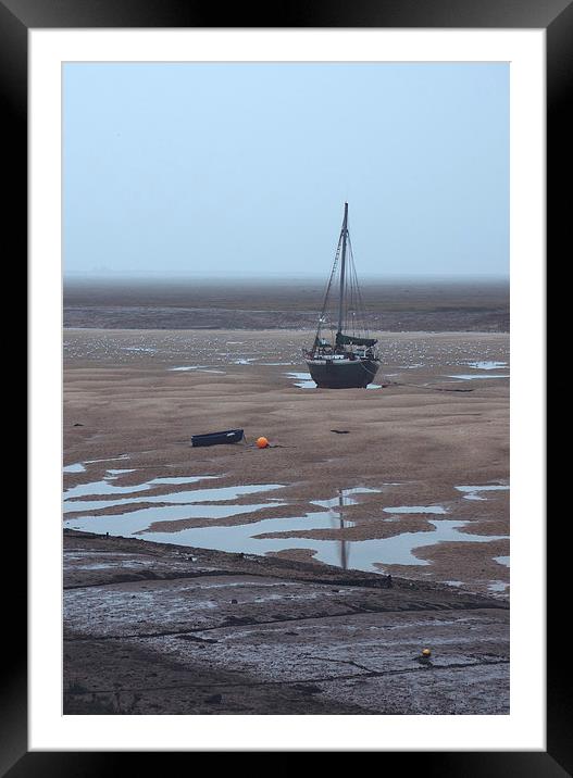 Boat at low tide on a foggy evening. Wells-next-th Framed Mounted Print by Liam Grant