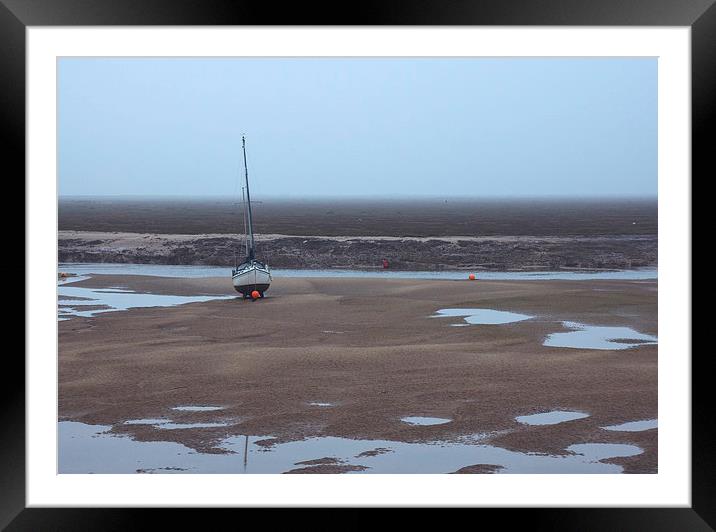 Boat at low tide on a foggy evening. Wells-next-th Framed Mounted Print by Liam Grant