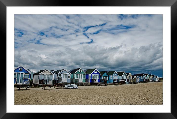 Stormy skys over beach huts Framed Mounted Print by Dan Ward