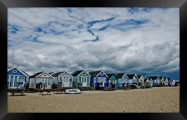 Stormy skys over beach huts Framed Print by Dan Ward