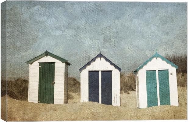 Three Little Beach Huts Sitting on a Beach Canvas Print by Lesley Mohamad