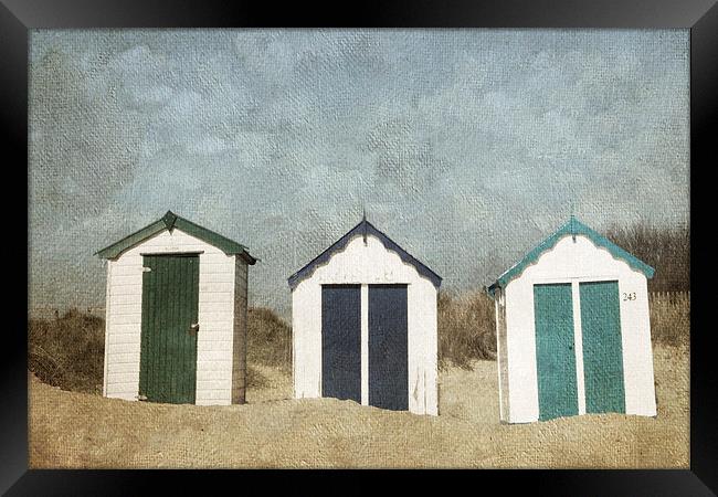 Three Little Beach Huts Sitting on a Beach Framed Print by Lesley Mohamad