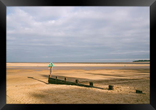 Green groyne marker and sunlit beach under a heavy Framed Print by Liam Grant