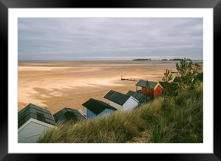 Beach huts and sunlit view out to sea. Framed Mounted Print by Liam Grant