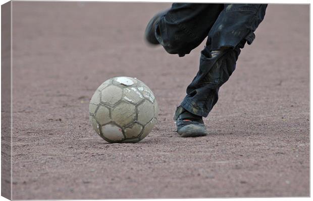 Boy is kicking a football Canvas Print by Matthias Hauser