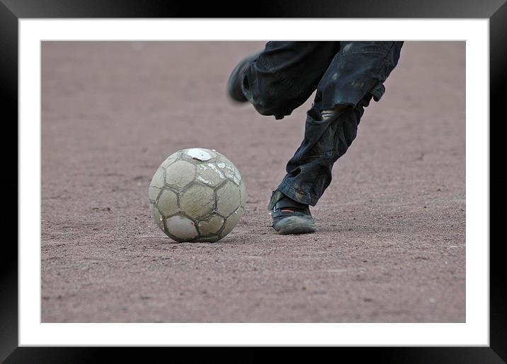 Boy is kicking a football Framed Mounted Print by Matthias Hauser