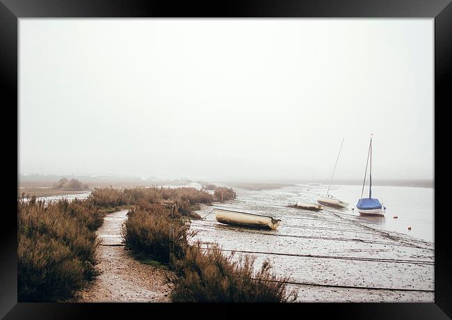 Boats moored at Blakeney in fog. Framed Print by Liam Grant
