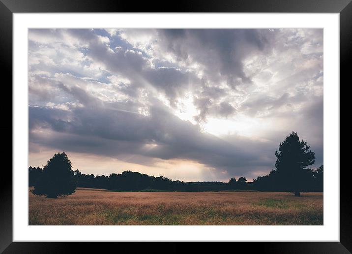 Sunlight breaks heavy cloud. Framed Mounted Print by Liam Grant