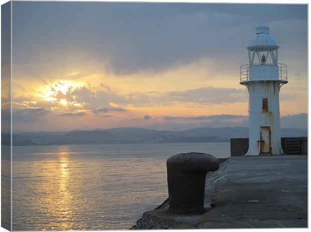  Brixham lighthouse by sunset Canvas Print by Ann Biddlecombe