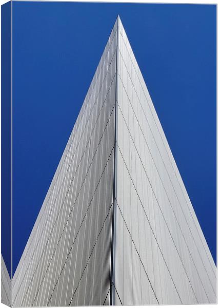 An angular building pierces a blue sky  Canvas Print by Jamie Lumley