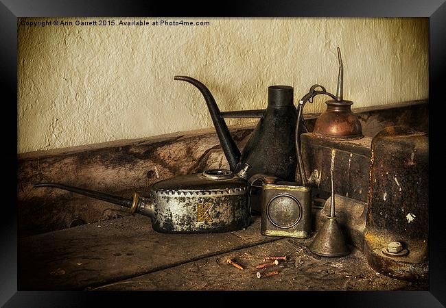 Oil Cans on the Workbench Framed Print by Ann Garrett