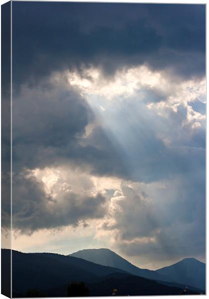 Sun rays through storm clouds Canvas Print by ken biggs