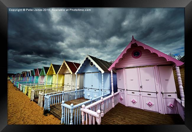 Row of colourful beach shelters.  Framed Print by Peter Jones