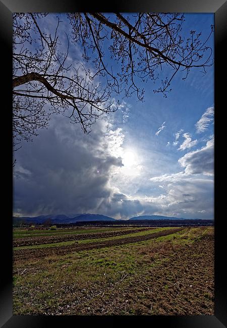 Spring plowing with angry clouds in the sky Framed Print by Adrian Bud