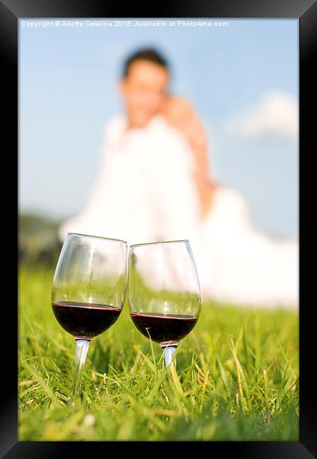 two wineglasses with red wine in grass  Framed Print by Arletta Cwalina