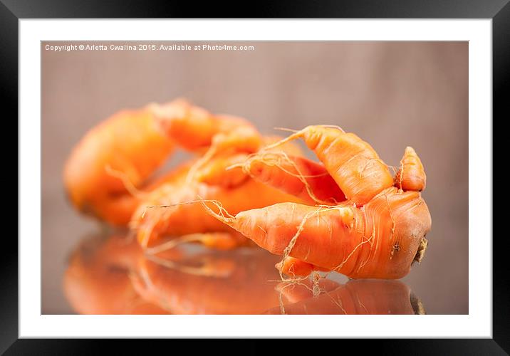 deformed carrot roots with forks lying on glass  Framed Mounted Print by Arletta Cwalina
