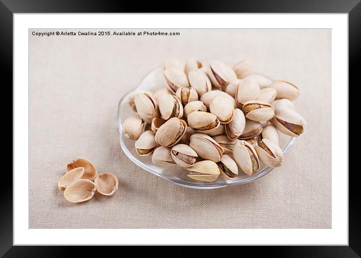 pistachio nuts in shell lying on glass plate  Framed Mounted Print by Arletta Cwalina