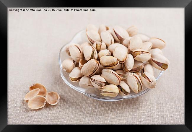 pistachio nuts in shell lying on glass plate  Framed Print by Arletta Cwalina