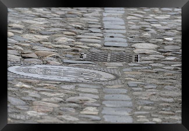 Paving of river rock and manhole covers cast iron Framed Print by Adrian Bud