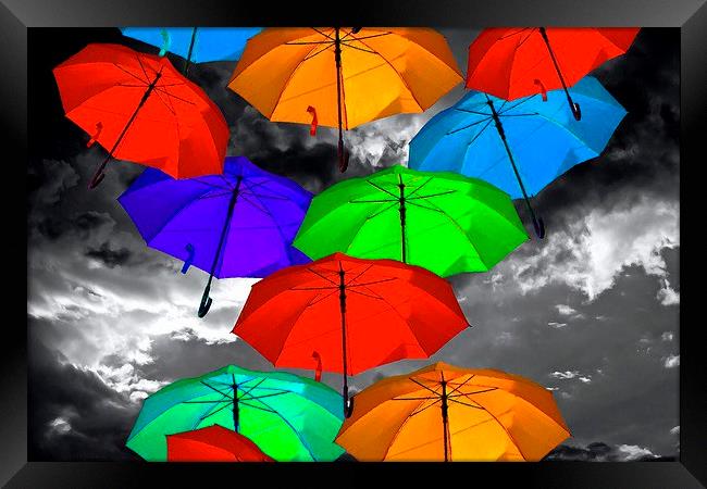 colorful umbrellas against a stormy sky Framed Print by ken biggs