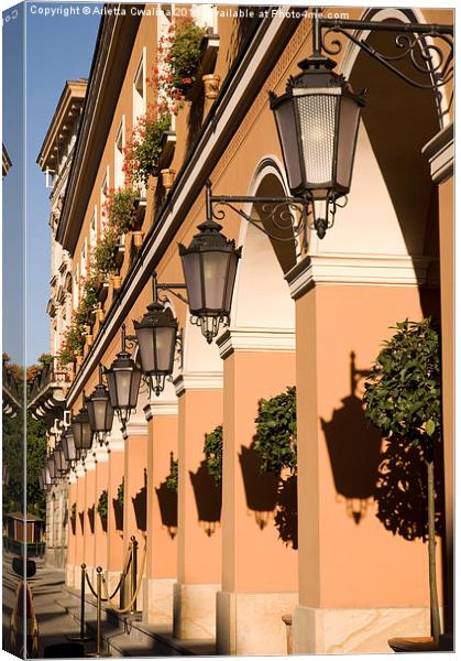 Row of lamps on columns of building  Canvas Print by Arletta Cwalina