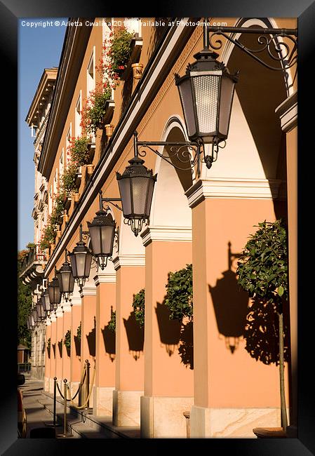 Row of lamps on columns of building  Framed Print by Arletta Cwalina
