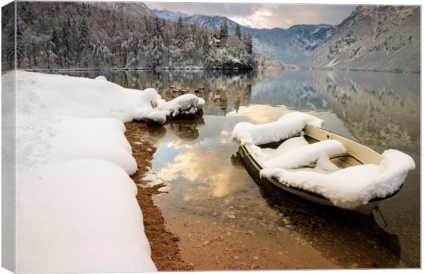 Snow covered boat on Lake Bohinj in Winter Canvas Print by Ian Middleton