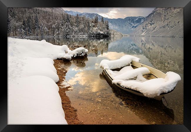 Snow covered boat on Lake Bohinj in Winter Framed Print by Ian Middleton