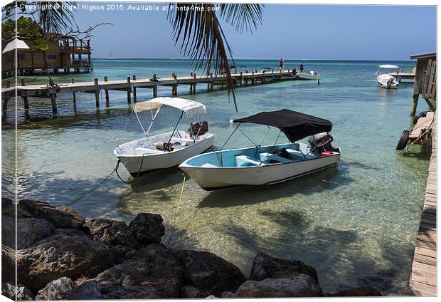  Boats rest in the clear waters of Roatan Canvas Print by Nigel Higson