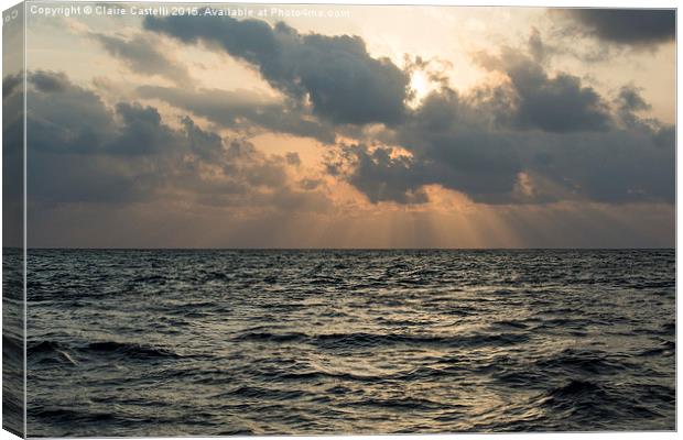 Sun rays over the ocean Canvas Print by Claire Castelli