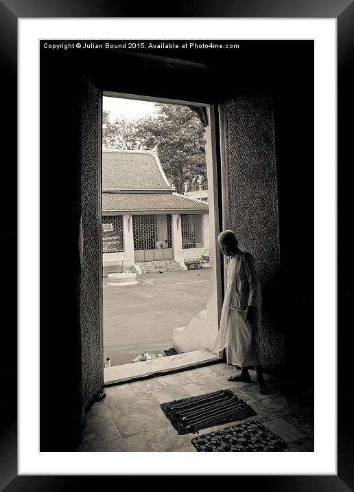 A nun in a doorway of a temple in Bangkok, Thailan Framed Mounted Print by Julian Bound