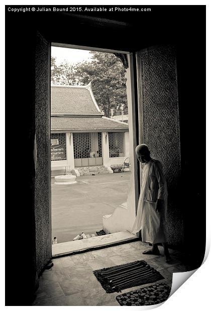 A nun in a doorway of a temple in Bangkok, Thailan Print by Julian Bound