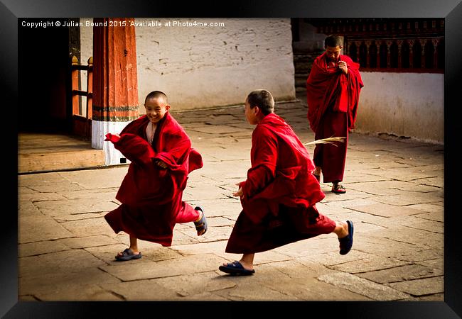 Monks at play in Rinpung Dzong Fort, Bhutan Framed Print by Julian Bound