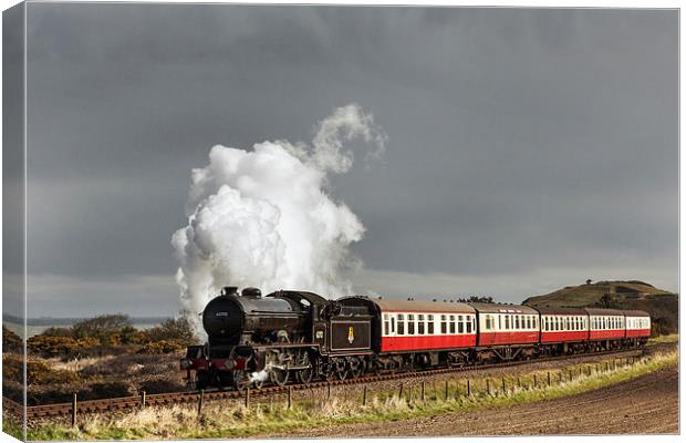 Steam train under storm clouds by the Coast Canvas Print by Ian Duffield